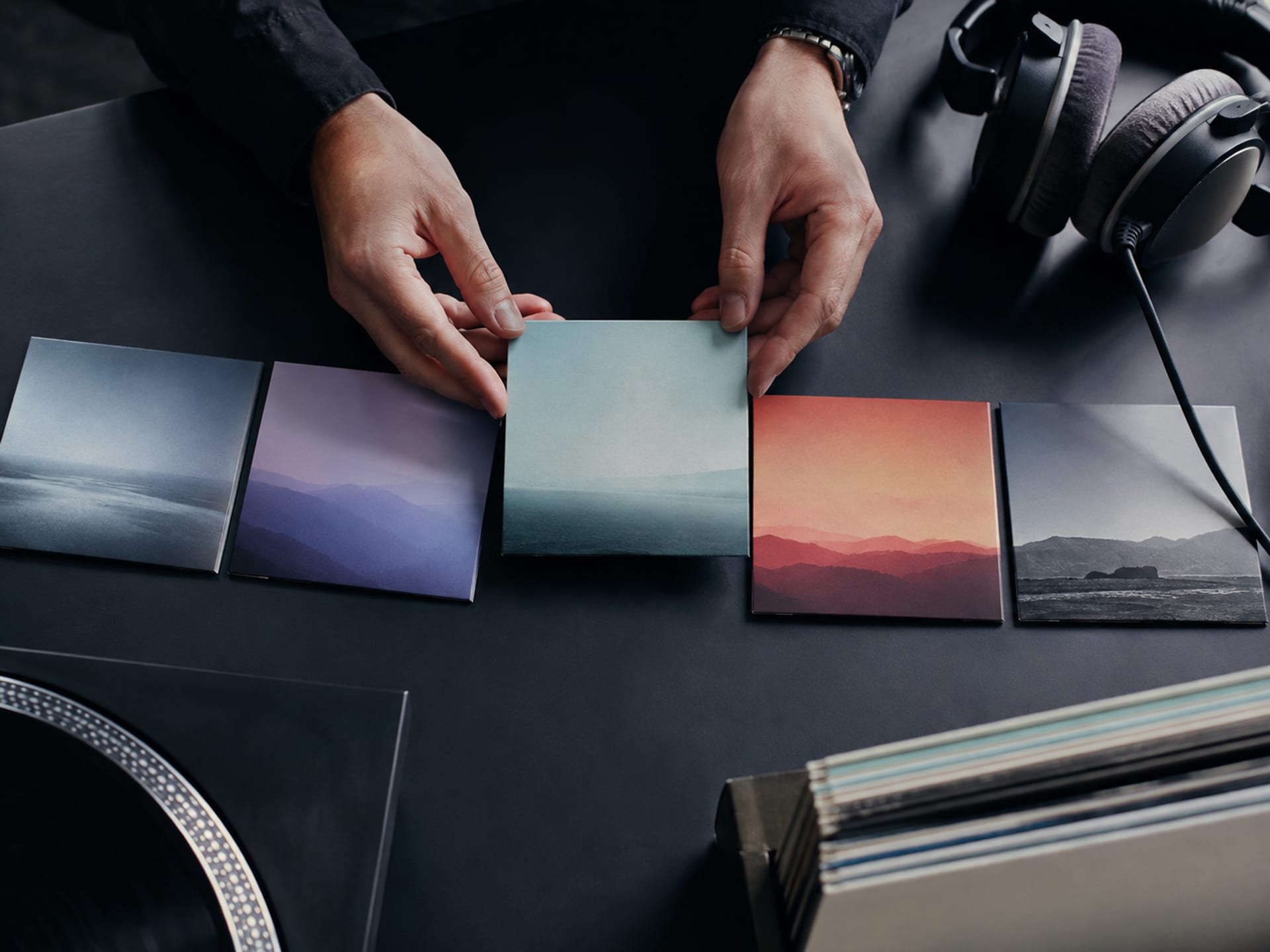 Mains disposant des pochettes de disques aux couleurs calmes, puis énergiques, puis de nouveau calmes pour illustrer l’ordre d’une playlist