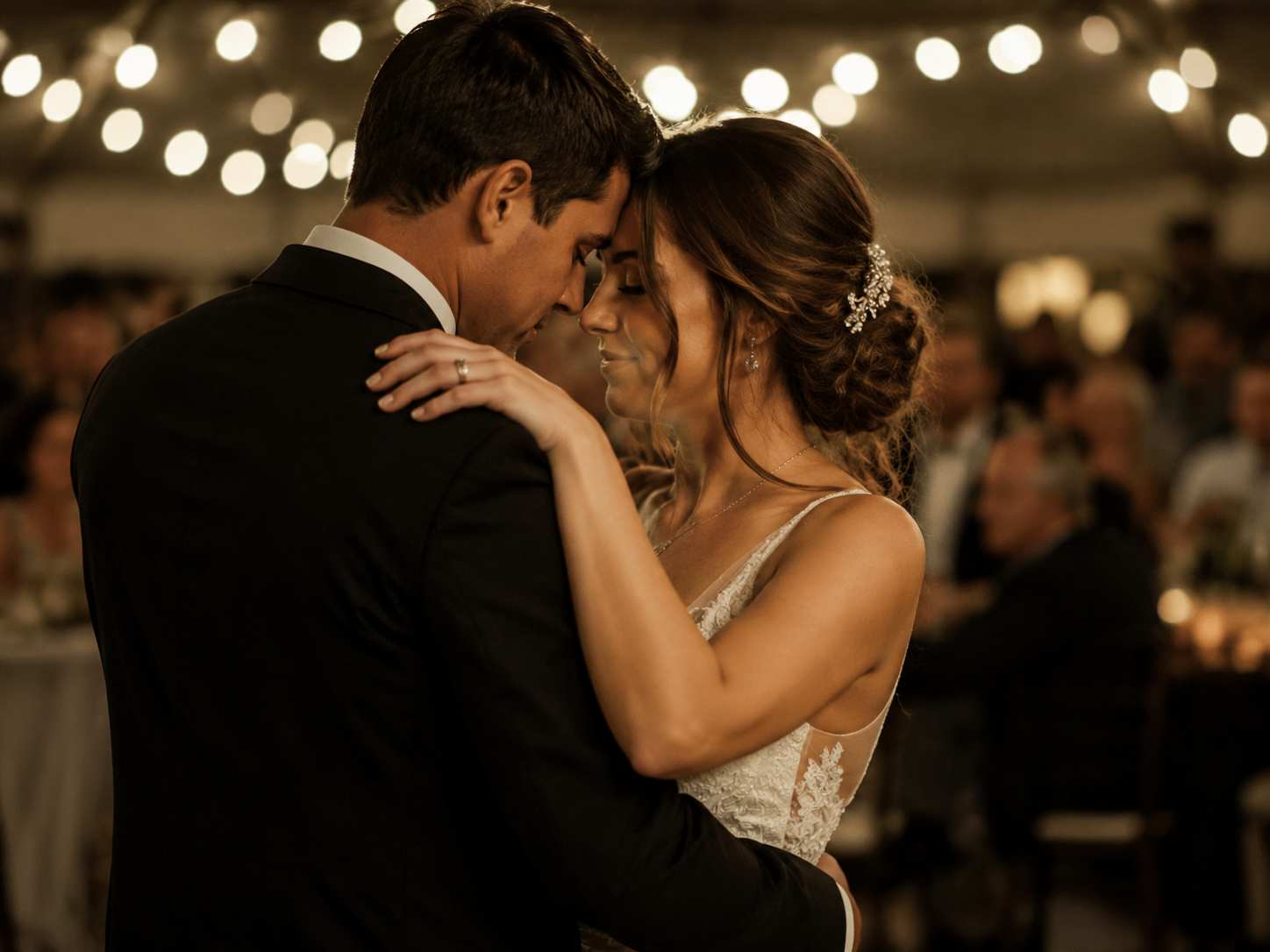Couple slow-dancing at a wedding reception with a personalized song playing on the speakers